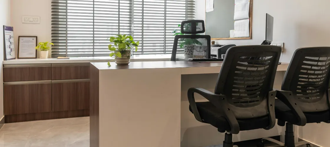 Sala de reuniones del despacho: mesa larga de madera, sillas y estanterías con tomos